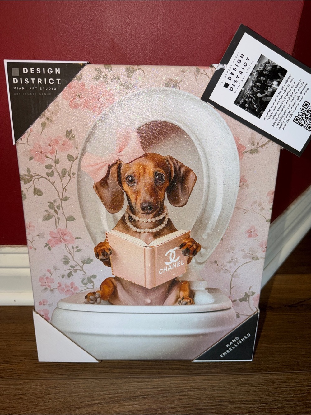 Design District Picture that Shows a Dog reading a Chanel book on the toilet